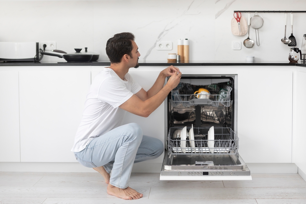 Man loading the dishwasher.