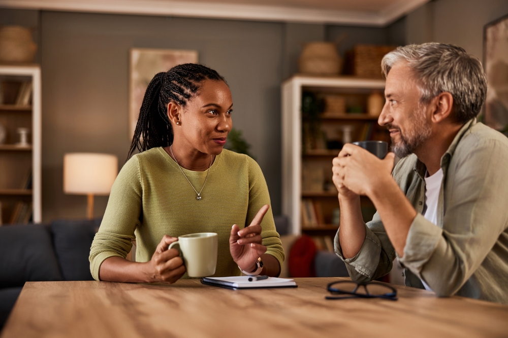 Two experienced individuals having a conversation with each other while having a drink