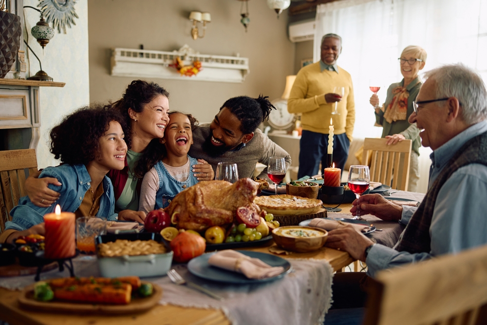 Happy parents and their children enjoying a family dinner with both grandparents