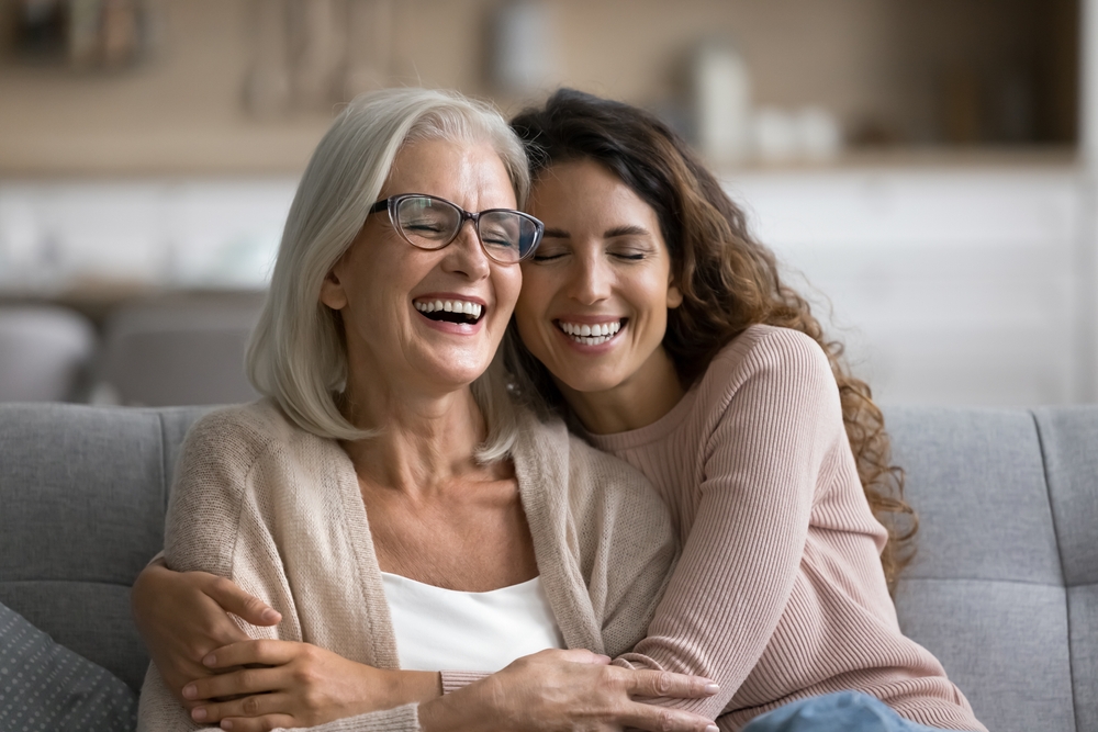 A happy senior woman and mother hugging her adult daughter