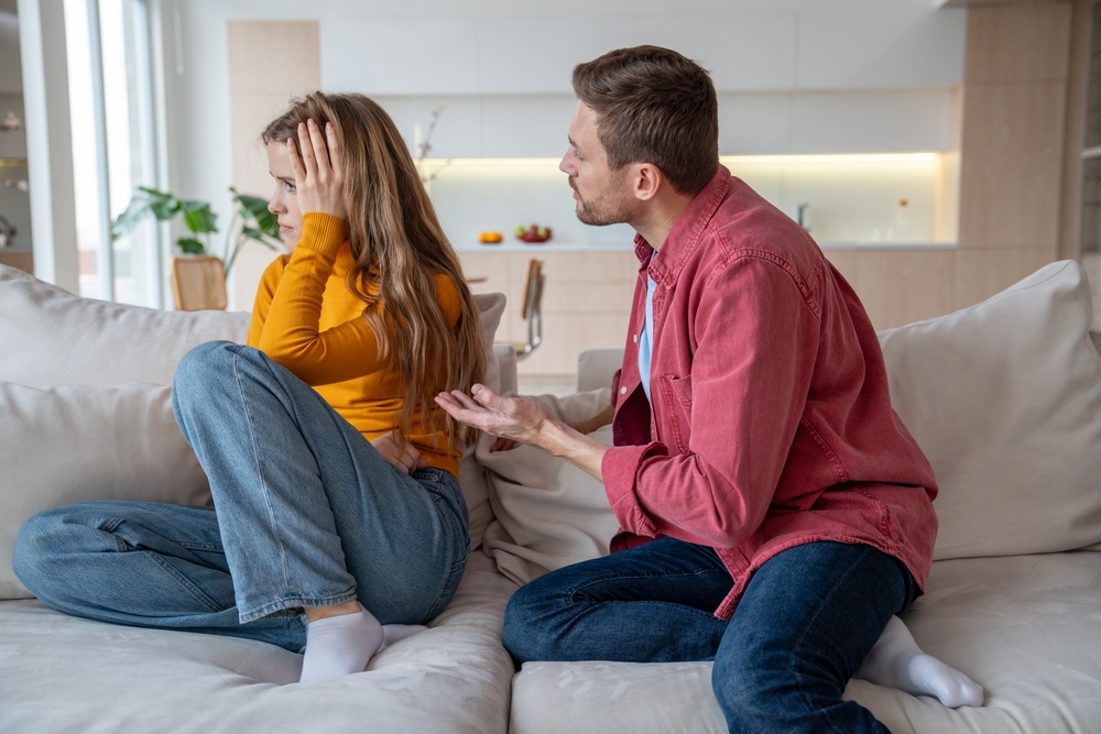 A displeased young woman manipulating her husband into talking to her