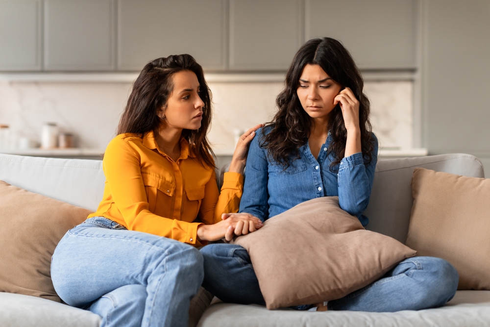 An attentive young woman listening to her friend and comforting her