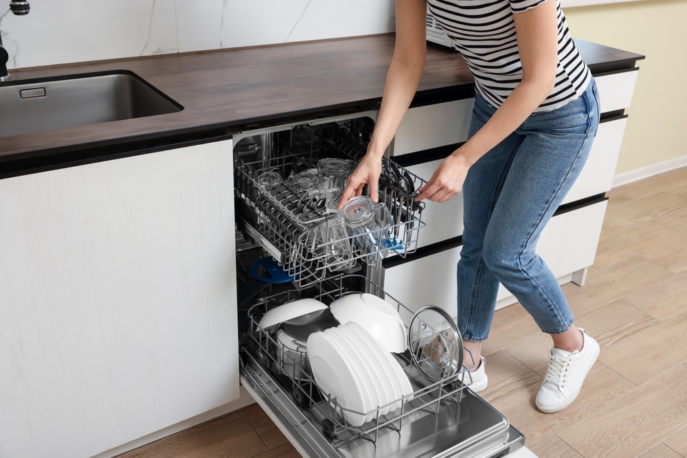 Woman loading the dishwasher.