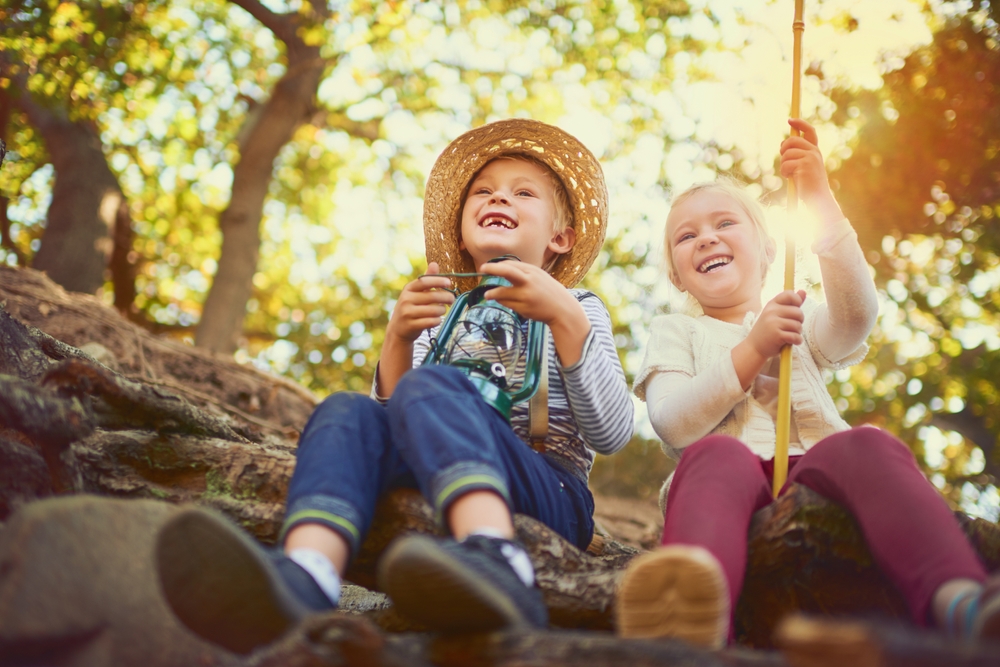 Children sitting together and playing outside. 