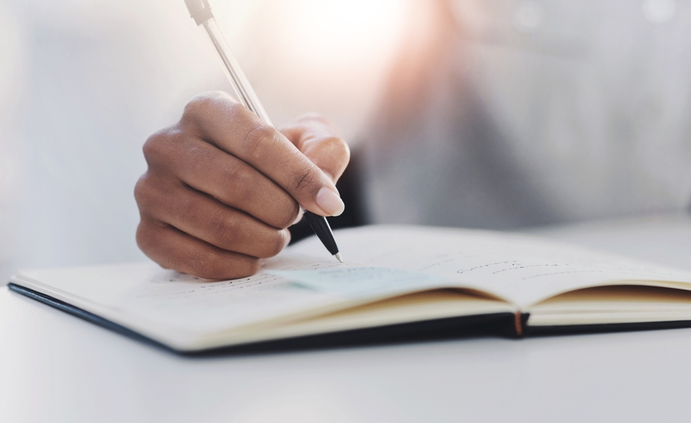 A hand writing in a book