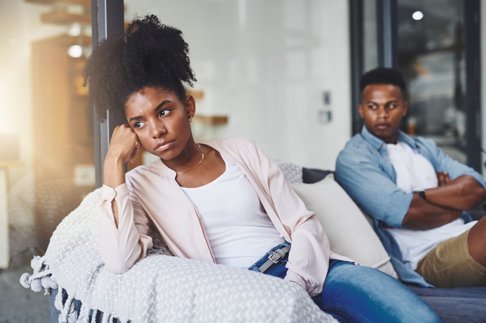 An angry couple sitting on the couch