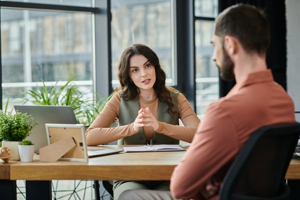 Two young colleagues having a conversation in the office