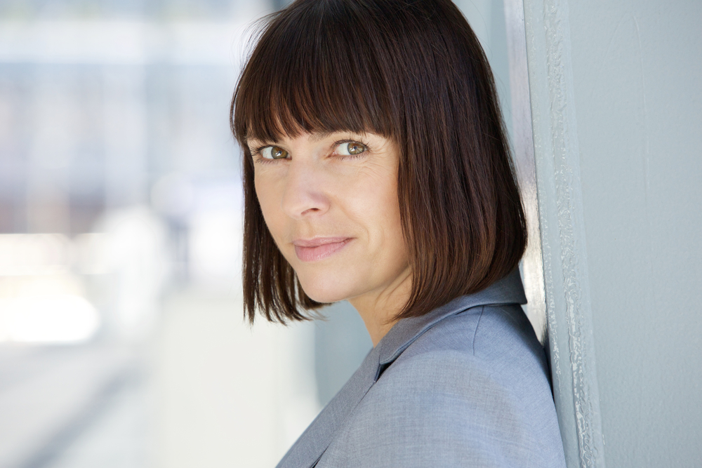 close up portrait of woman with a bob and bangs smiling