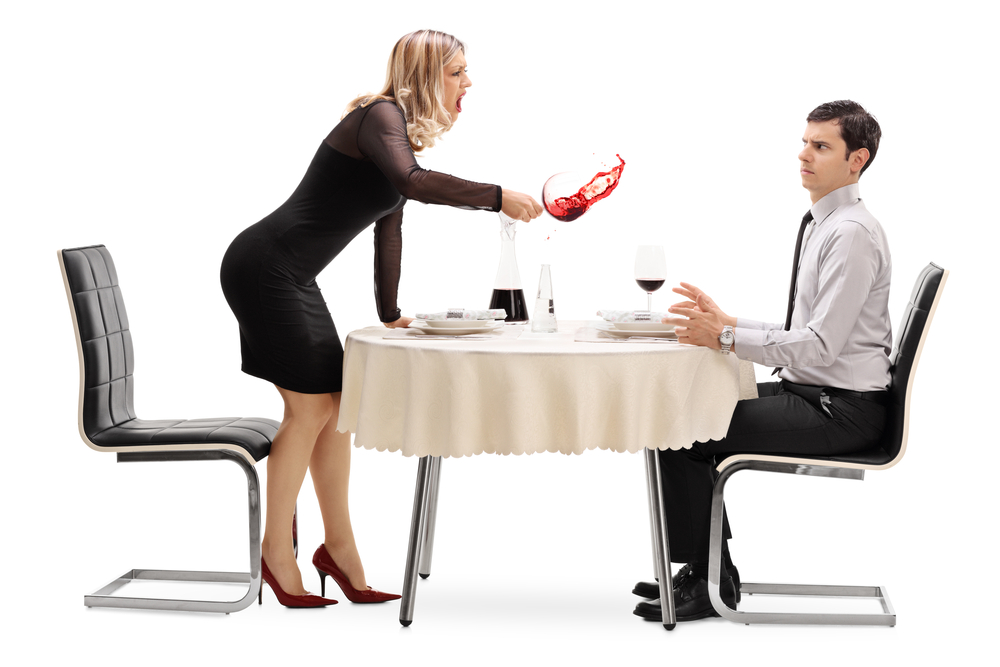 Angry woman spilling her drink on her date