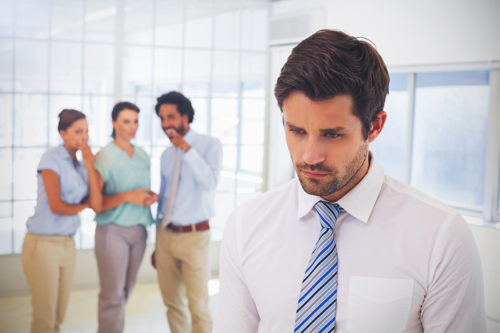 Three people gossiping about their work colleague in the office