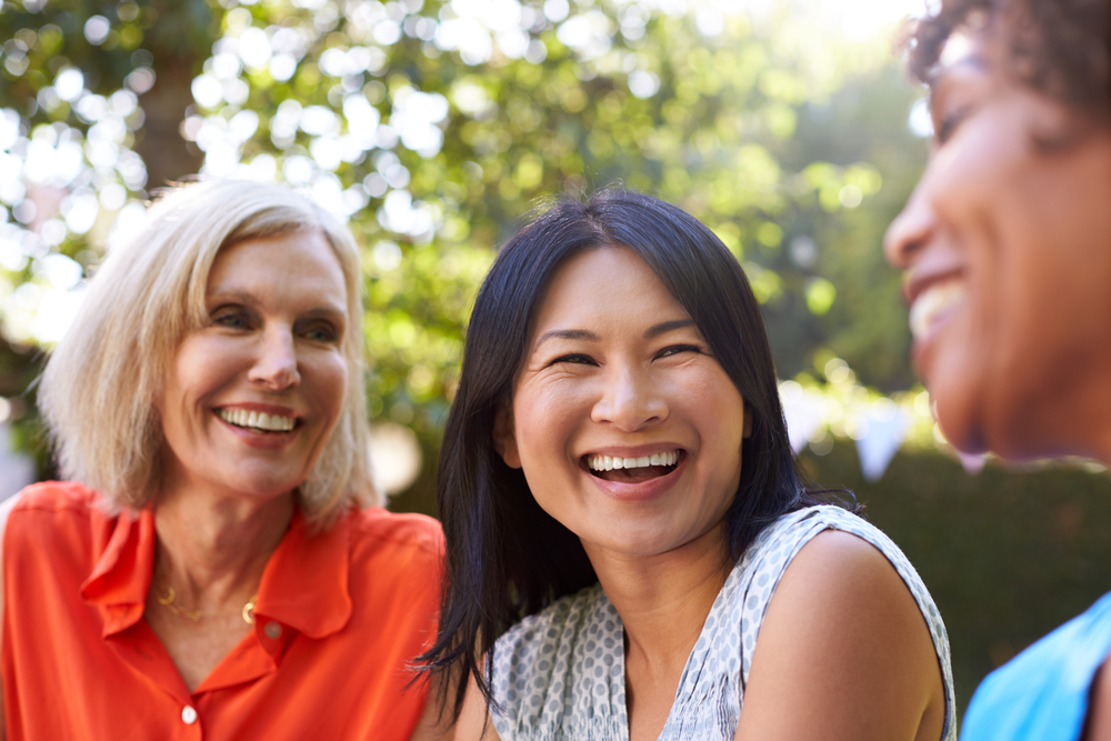Three female mature middle age friends laughing together