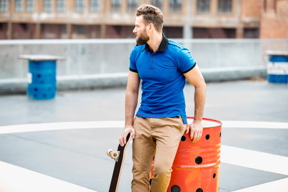 A man wearing a blue top while at the skate park.