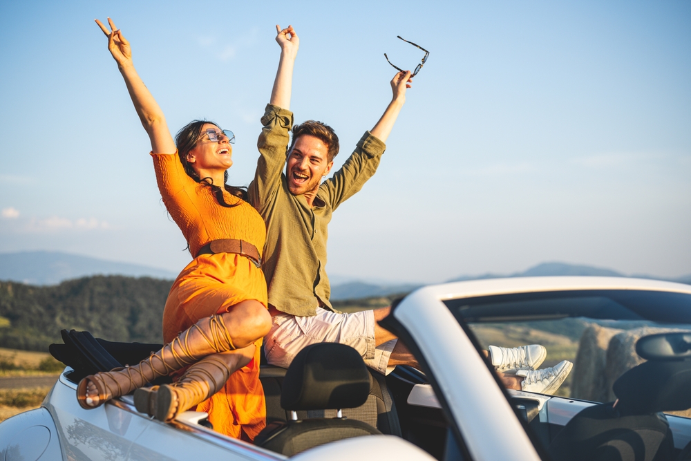 Sunset sun bath for a couple of lovers on their car roof