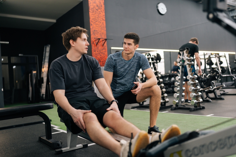 Two young men having a conversation at the gym