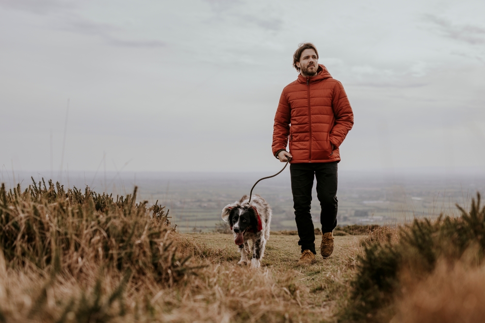 A mature man walking with his dog