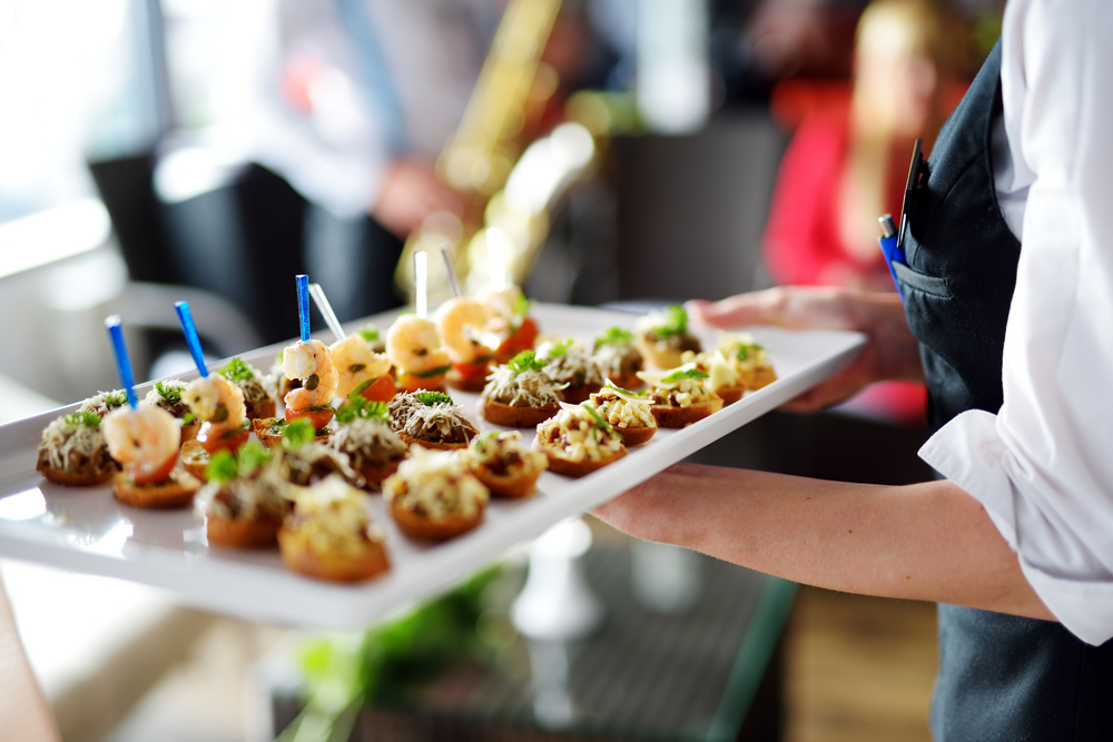 Woman carrying plates with food.