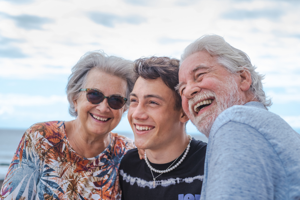 Grandparents at the beach spending time with their teenage grandson.