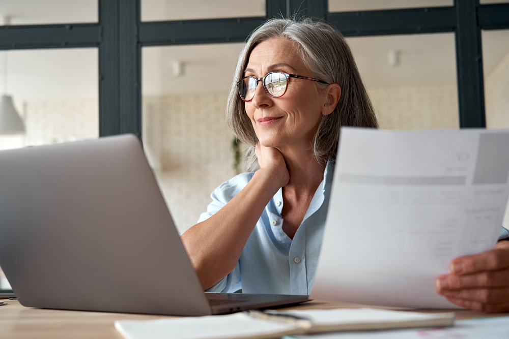 Smiling matured middle age business woman working with her laptop