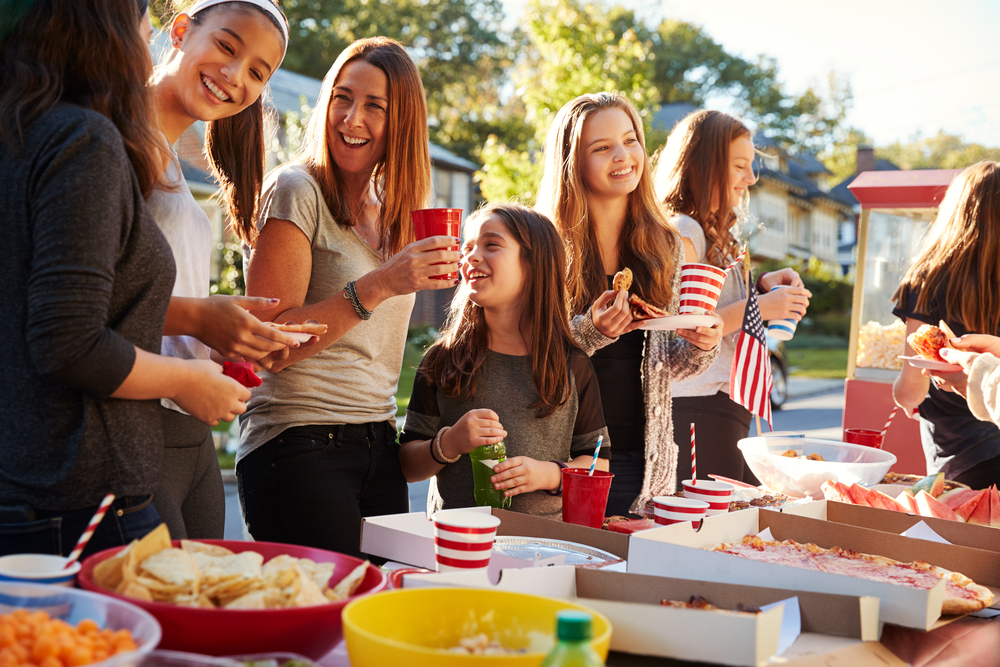 A group of female friends standing at a table at a block party
