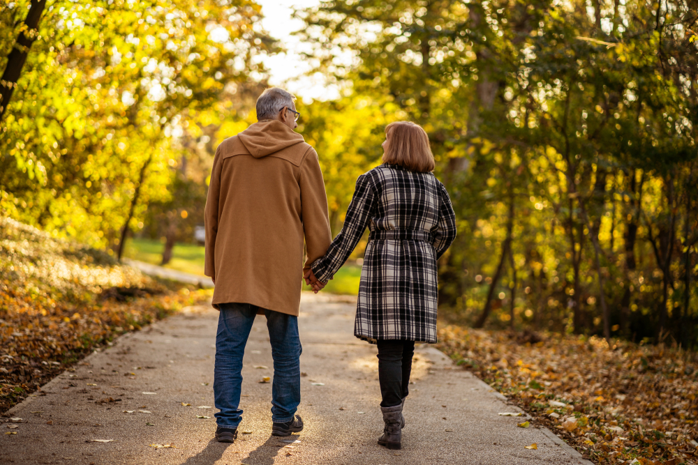 Senior retired couple holding hands and going on a walk in the afternoon