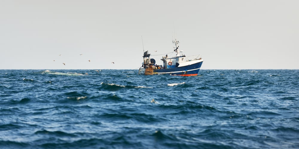 Small fishing boat sailing in the open mediterranean sea