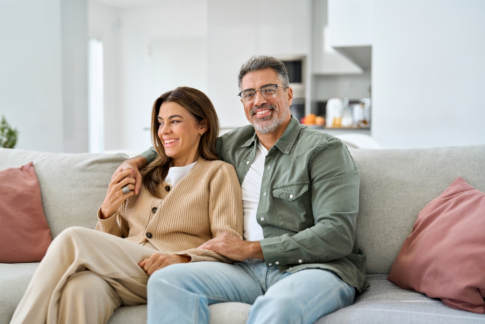 A middle aged couple snuggling on the couch in the living room