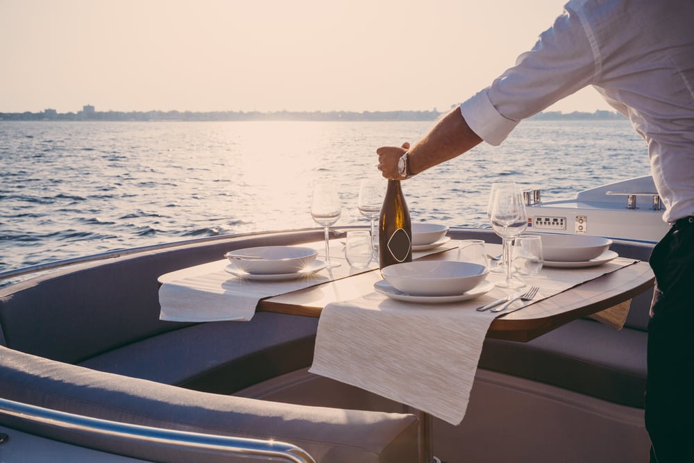 A man setting the table for a romantic lunch on a motorboat