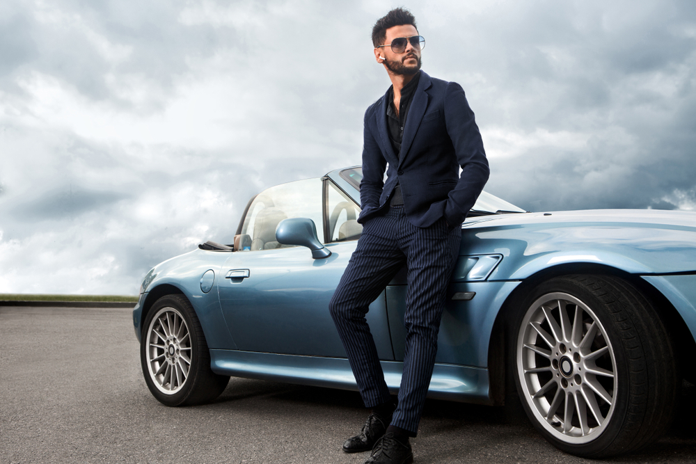 Handsome stylish man in a suit in front of a vintage car