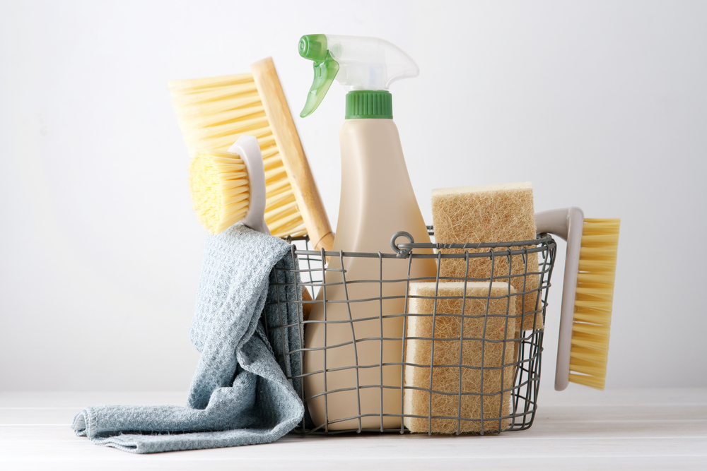Eco brushes, sponges, cleaning cloth and other cleaning supplies in a basket on a table
