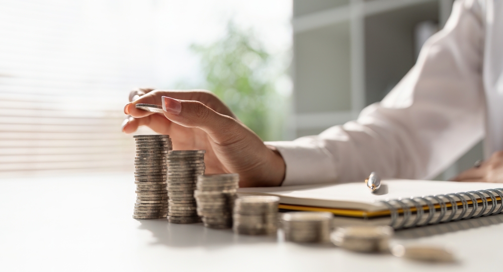 Woman making piles of coins.