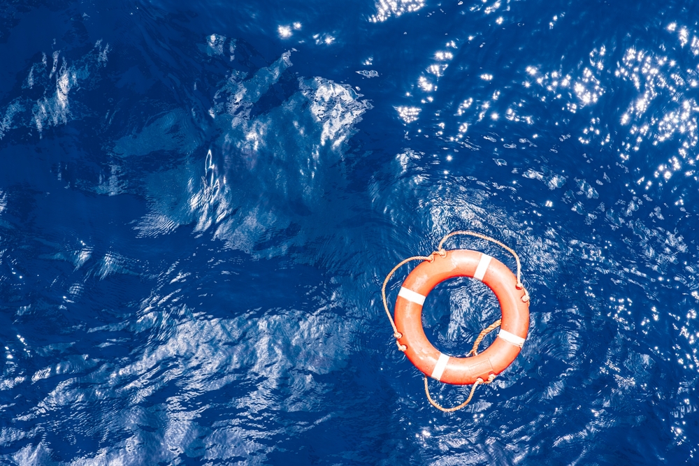 An orange lifebuoy floating in the ocean.
