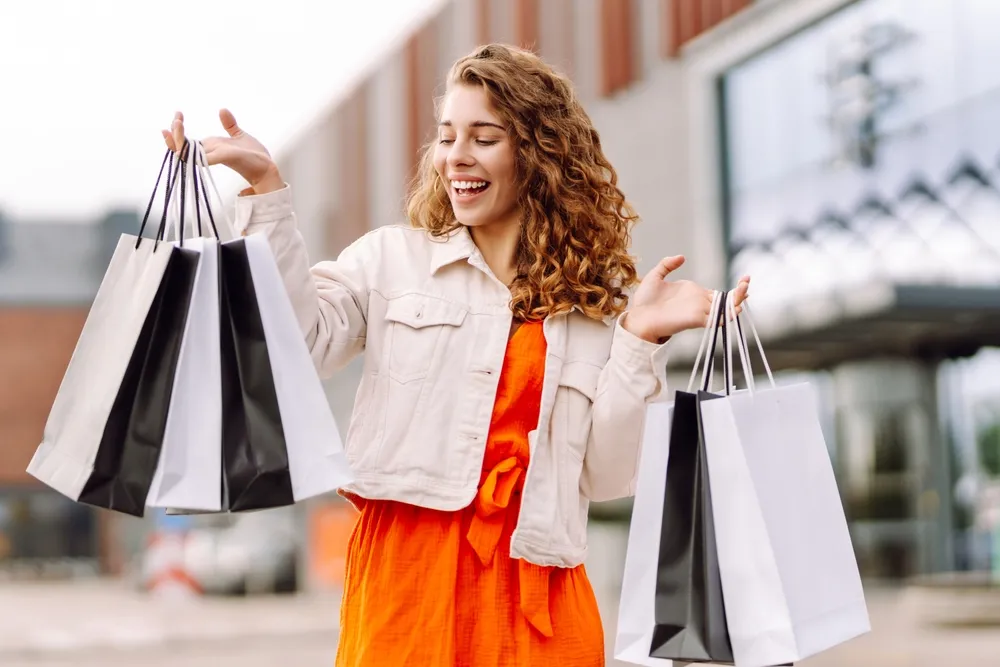 A woman out shopping in a bright orange dress.