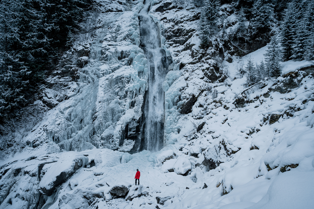 Hiker in snow with red jacket.