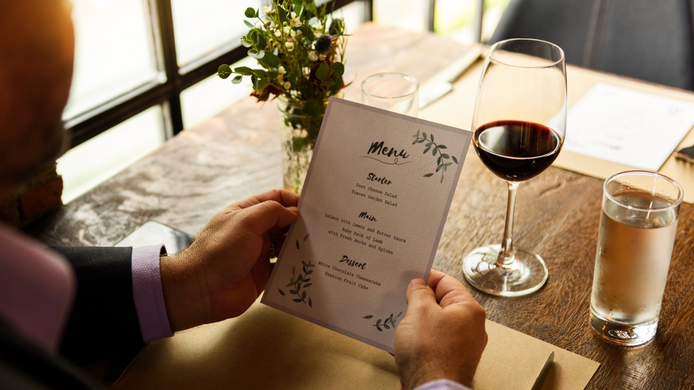 A man reviewing the menu at a restaurant. 