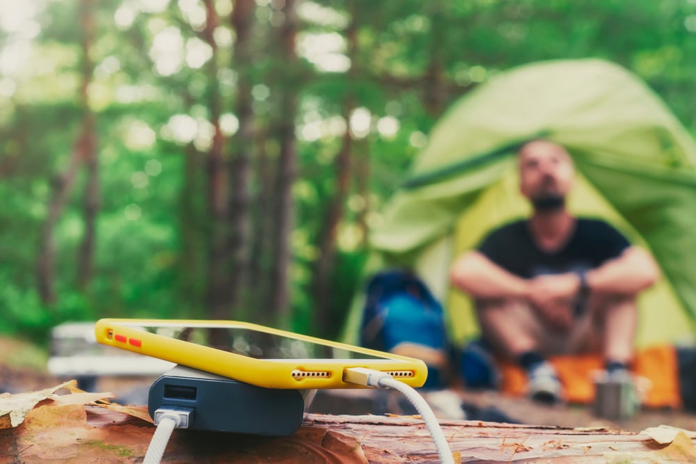 A smartphone is being charged outdoors with a powerbank