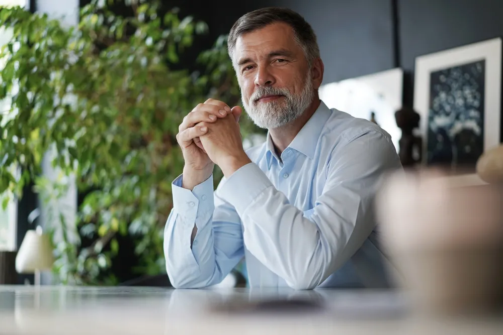 A mature man sitting at his desk.