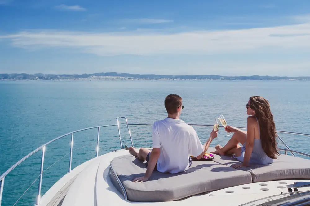 Rich wealthy couple drinking champagne on a yacht.