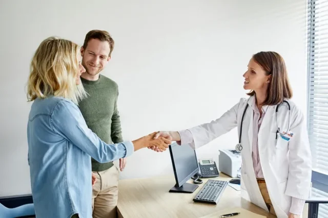 Healthcare Dr shaking hands with her female patient.