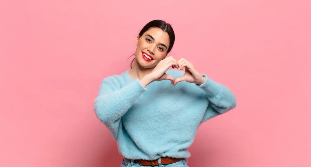 Beautiful woman making a heart sign.