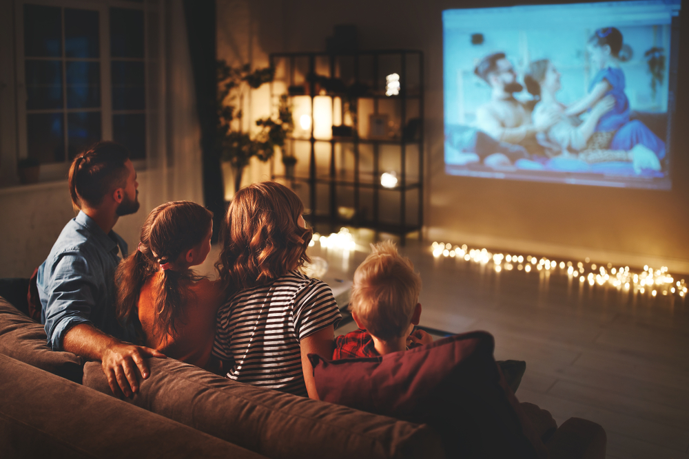 A family watching tv with father, mother and children