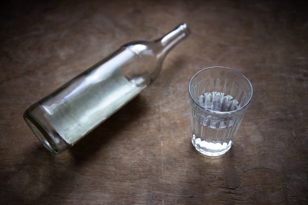 A glass with vodka bottle nearby.