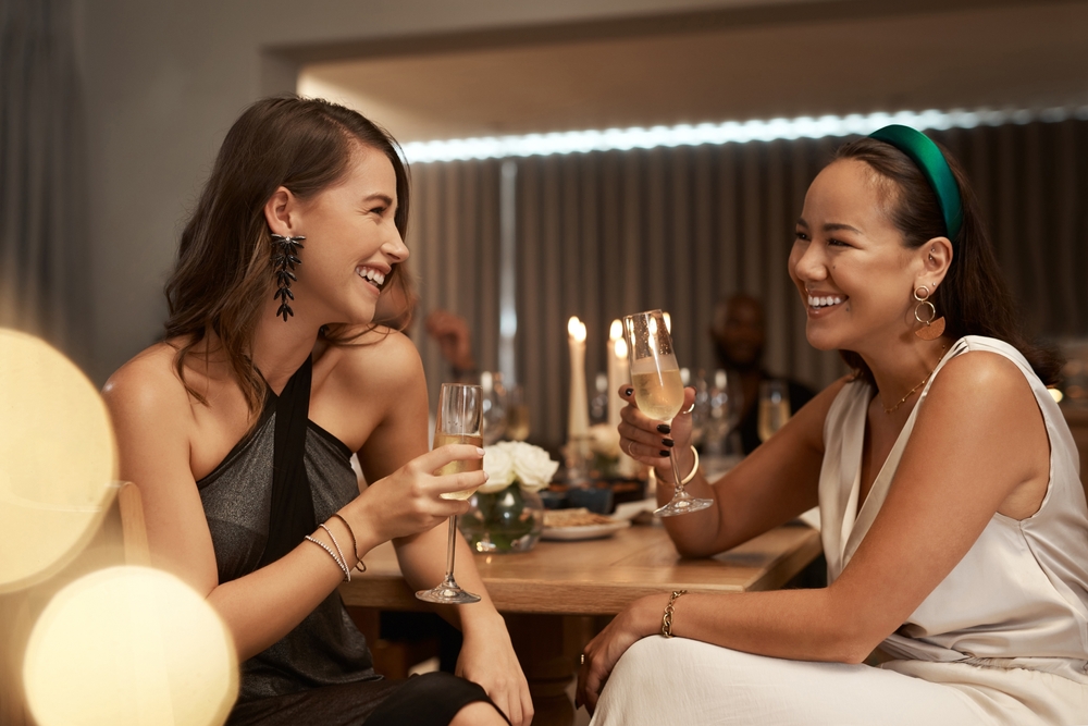 Two friends having fun at dinner and drinking champagne