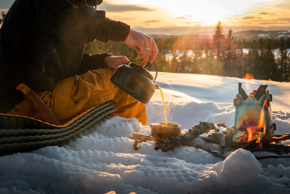 A woman is pouring a cup of coffee