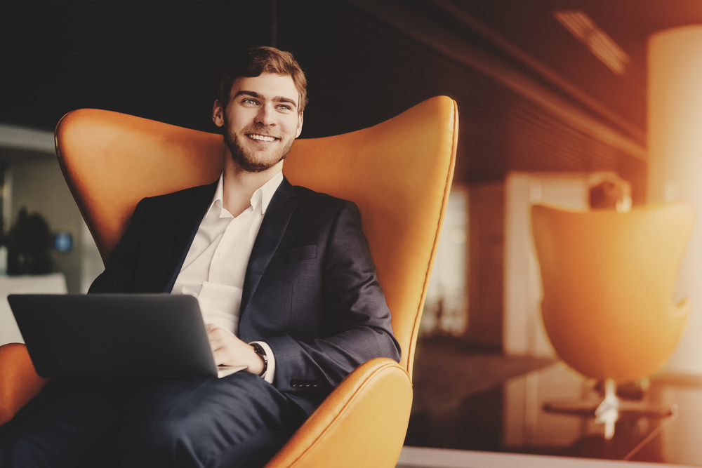 Handsome man smiling at his computer at the office