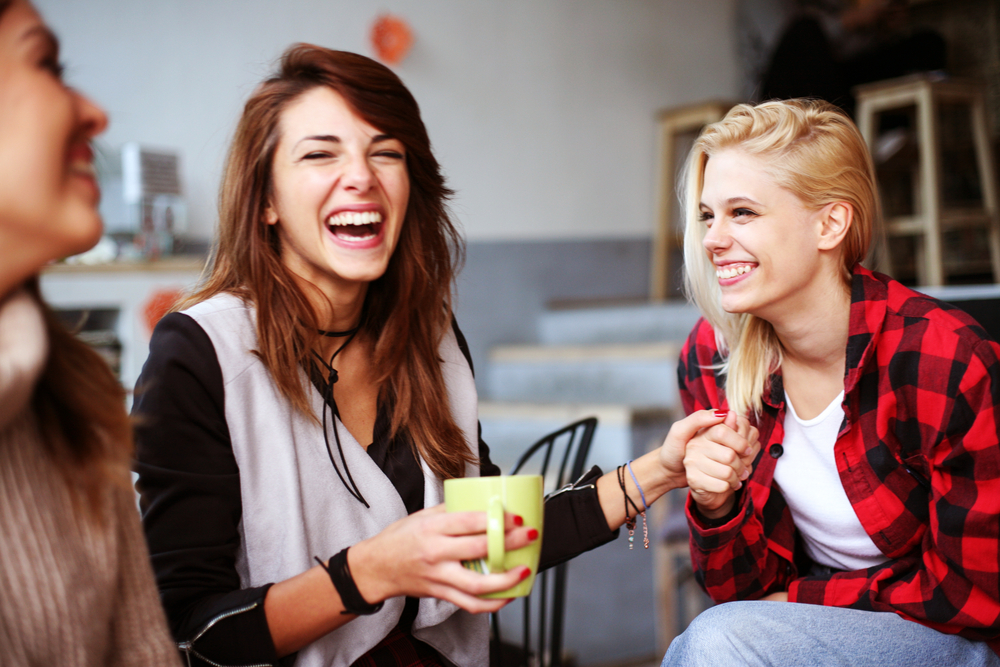 Three friends having coffee and laughing