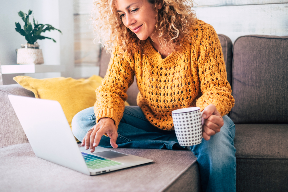 A middle age woman at her computer at home.