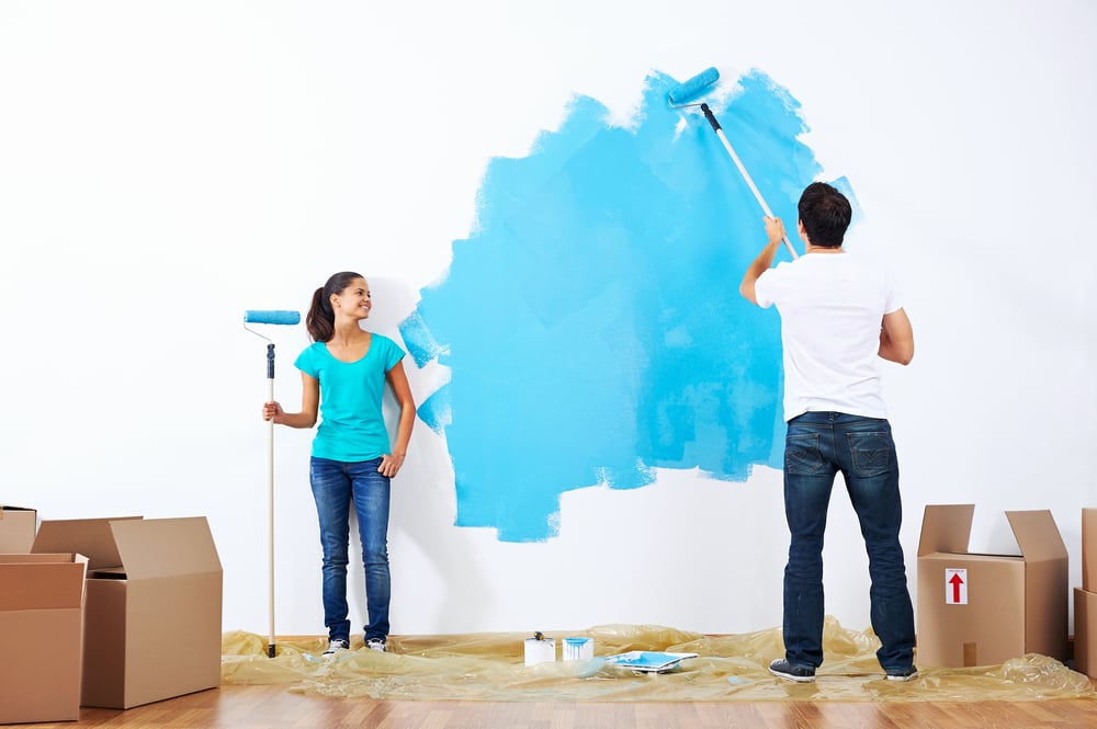 Couple painting their walls blue.