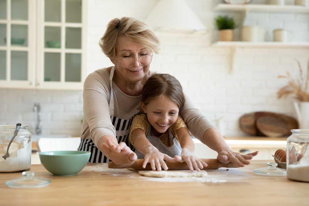 An elderly senior grandmother with her granddaughter helping out