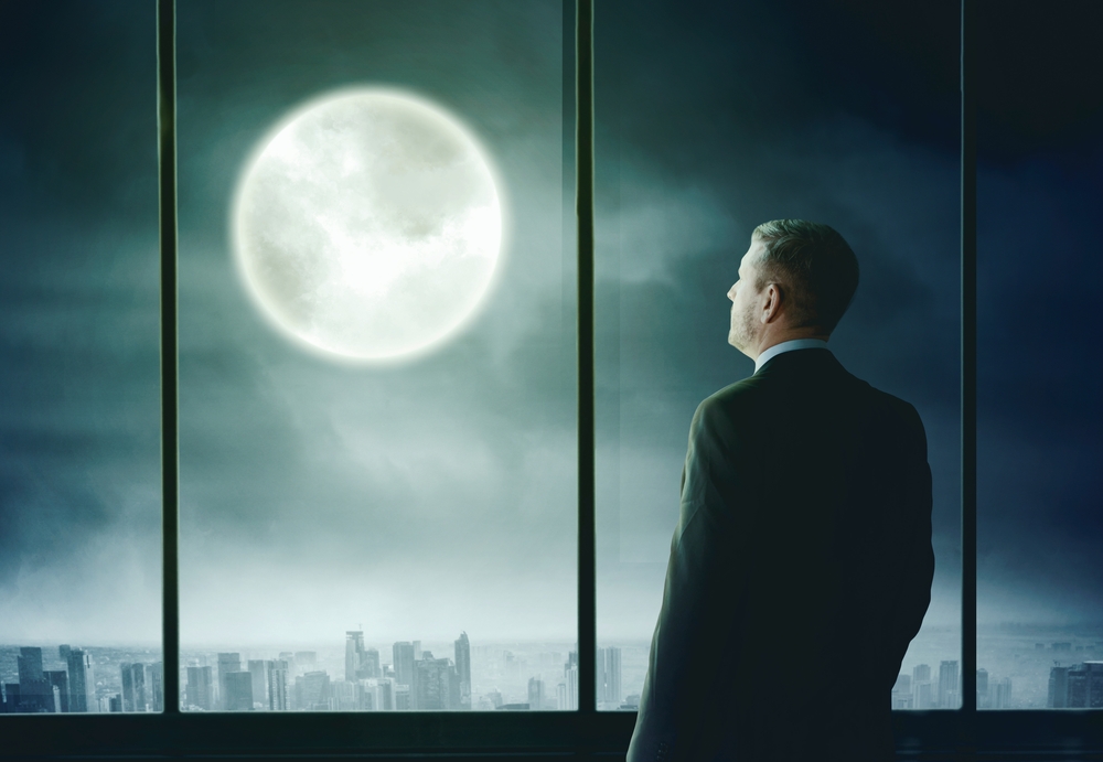 A man admiring the moon at night.