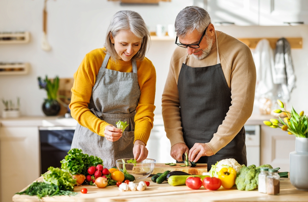 A happy senior couple cooking together.